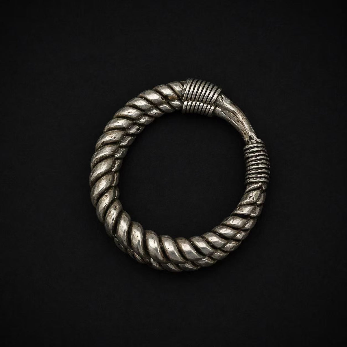Miao silver twisted cuff bracelet: Circular twisted cuff on a dark background