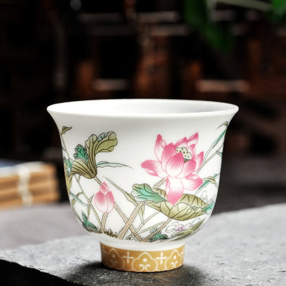 Dehua porcelain tea cup with a pink lotus flower, lotus bud and green leaves