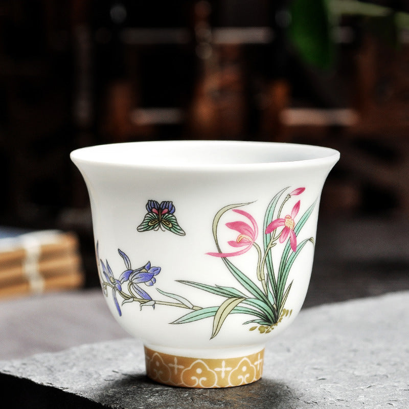 Dehua porcelain tea cup with pink and purple flowers, long leaves and a butterfly motif