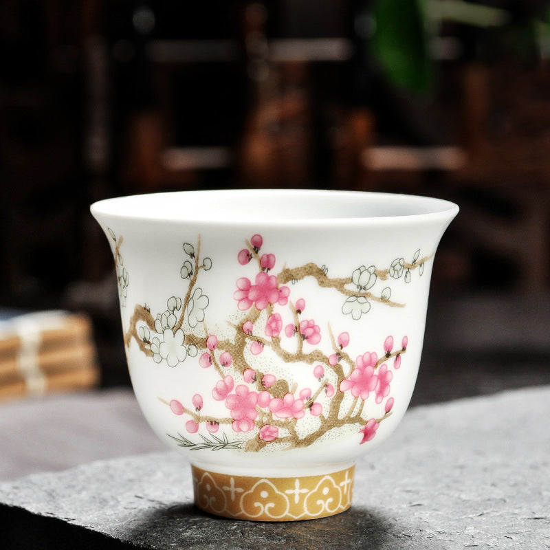 Dehua porcelain tea cup with pink and white plum blossoms on spreading brown branches
