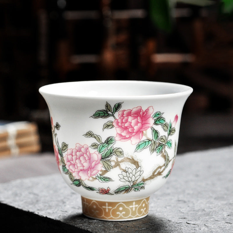 Dehua porcelain tea cup with rounded pink blooms and a small white flower along a curved branch