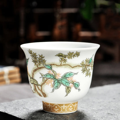 Dehua porcelain tea cup with small yellow blossoms, branching stems and green leaves