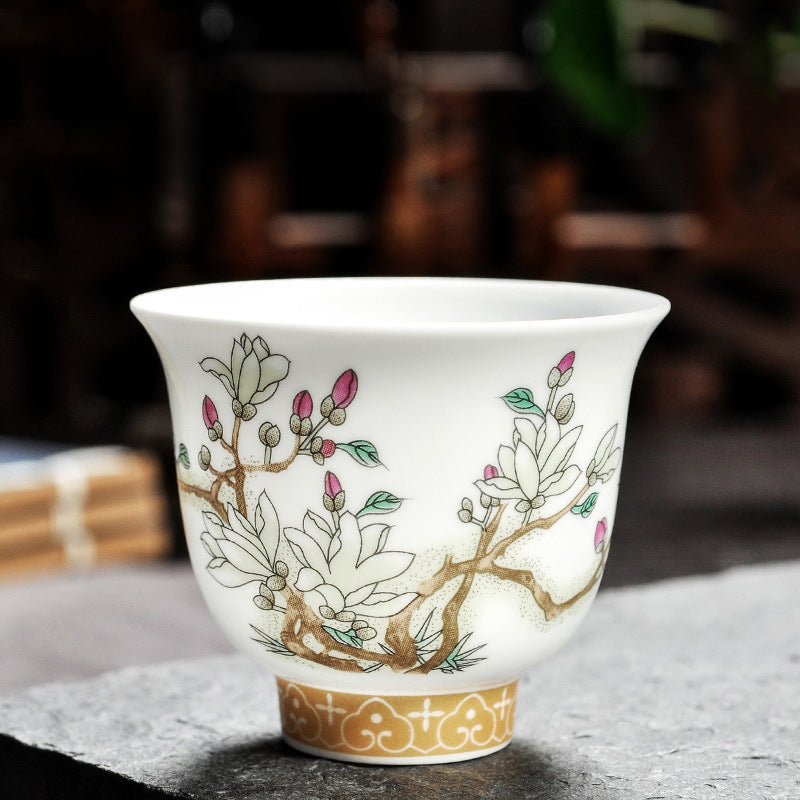 Dehua porcelain tea cup with white magnolia blossoms and pink buds on branching stems