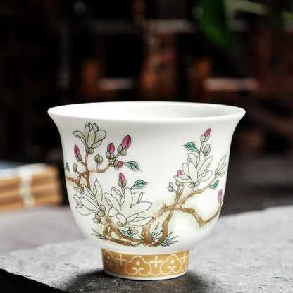 Dehua porcelain tea cup with white magnolia blossoms and pink buds on branching stems