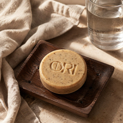 Heartleaf and goat milk soap bar: Lying in a wooden soap dish