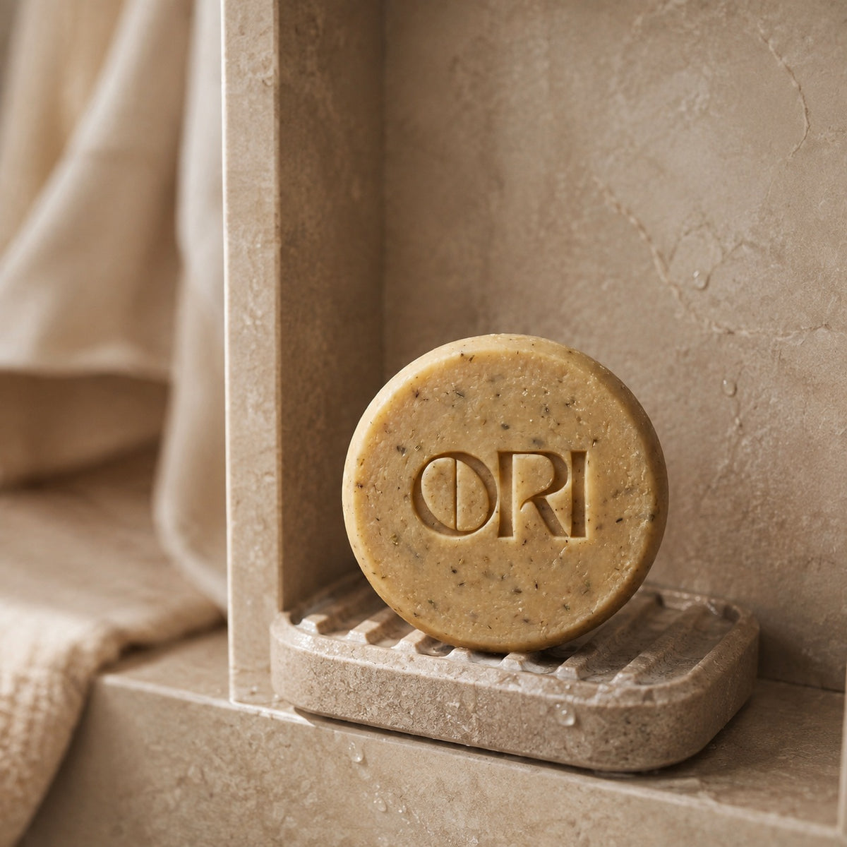 Heartleaf and goat milk soap bar: Standing on a stone dish beside linen