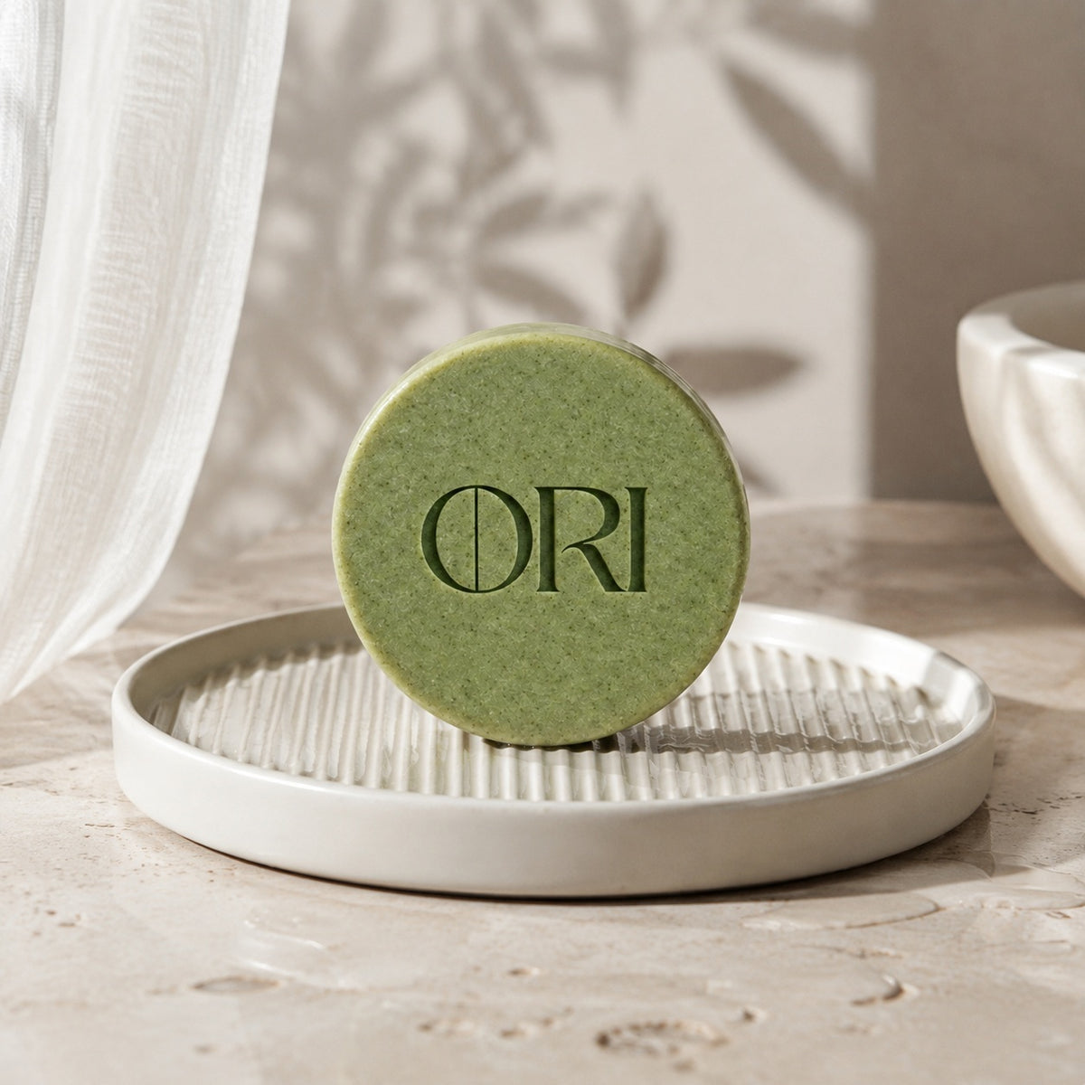Matcha green tea soap bar: Standing on a white ridged soap dish