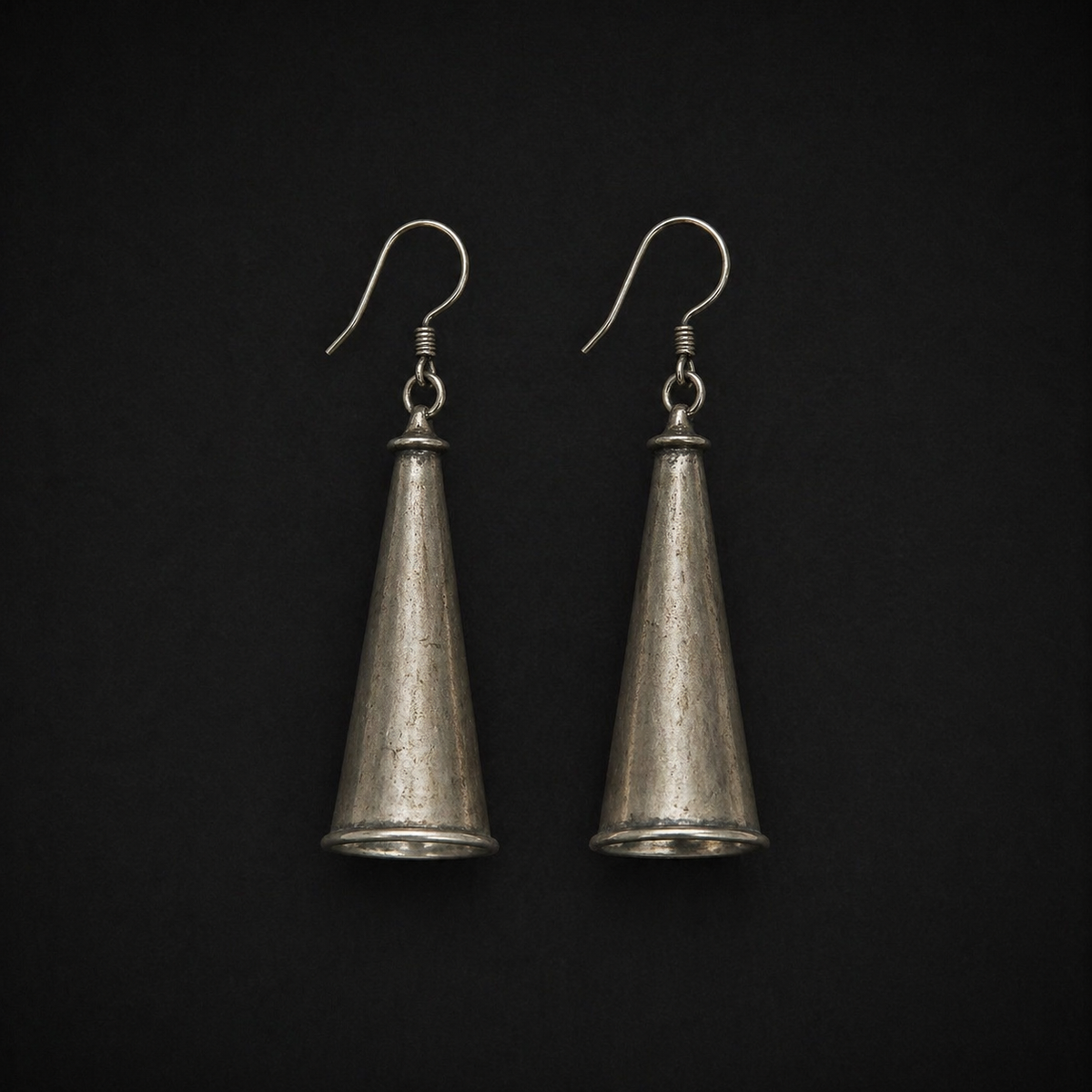 Miao silver conical drop earrings: Pair of conical silver drop earrings on a dark background