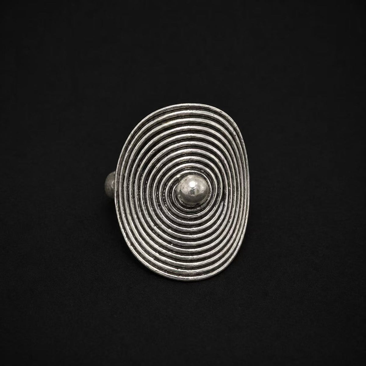 Miao silver oval spiral ring: Oval spiral face on a dark background