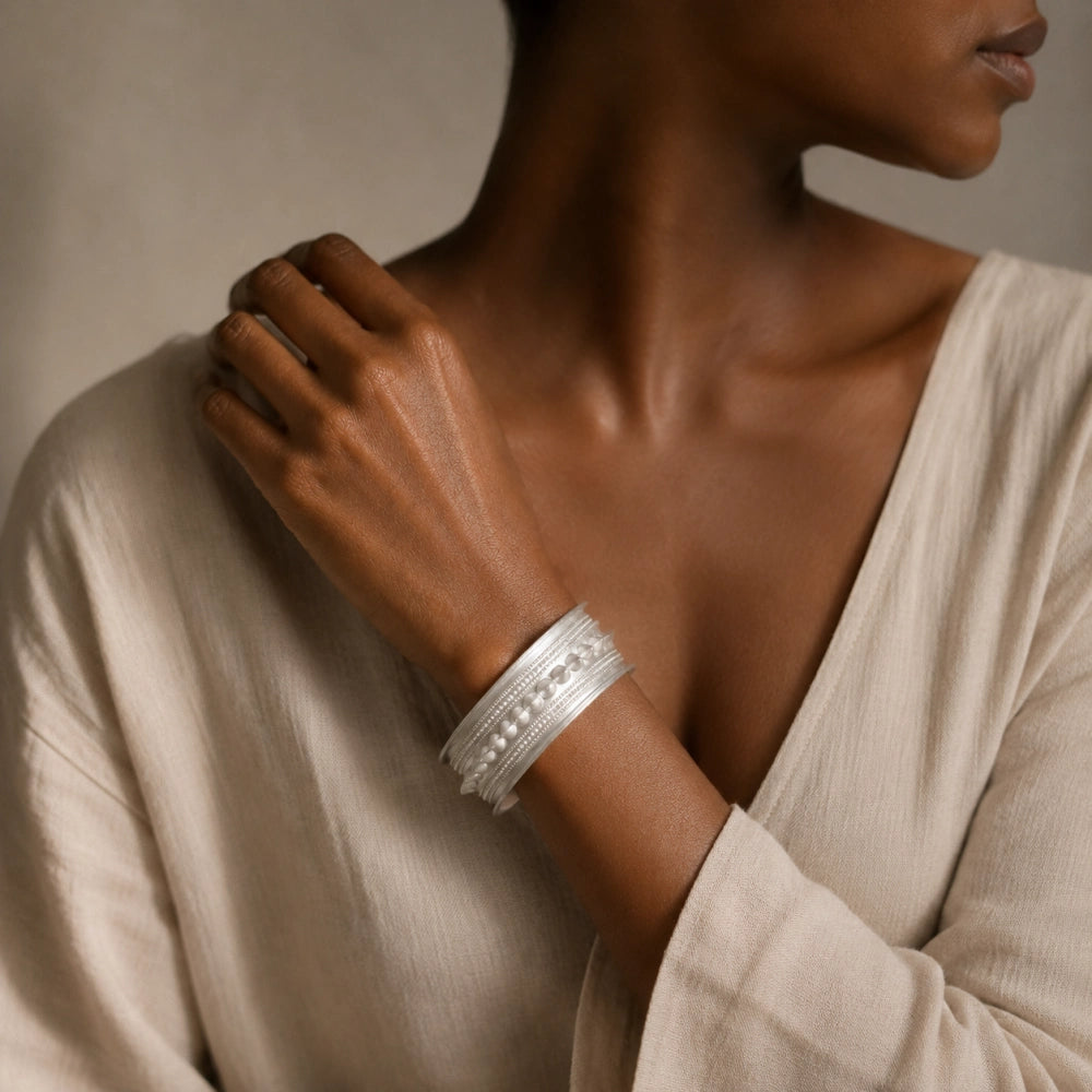 Miao silver patterned bracelet: Patterned bracelet worn with a pale long-sleeved blouse
