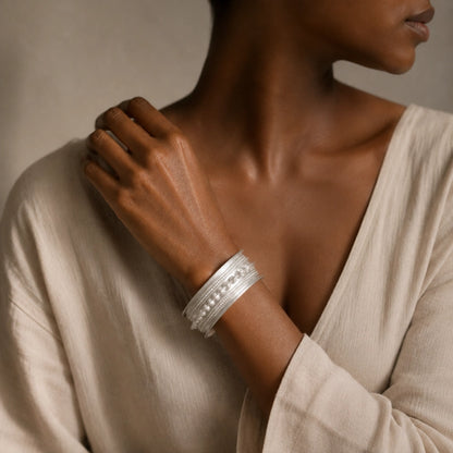 Miao silver patterned bracelet: Patterned bracelet worn with a pale long-sleeved blouse