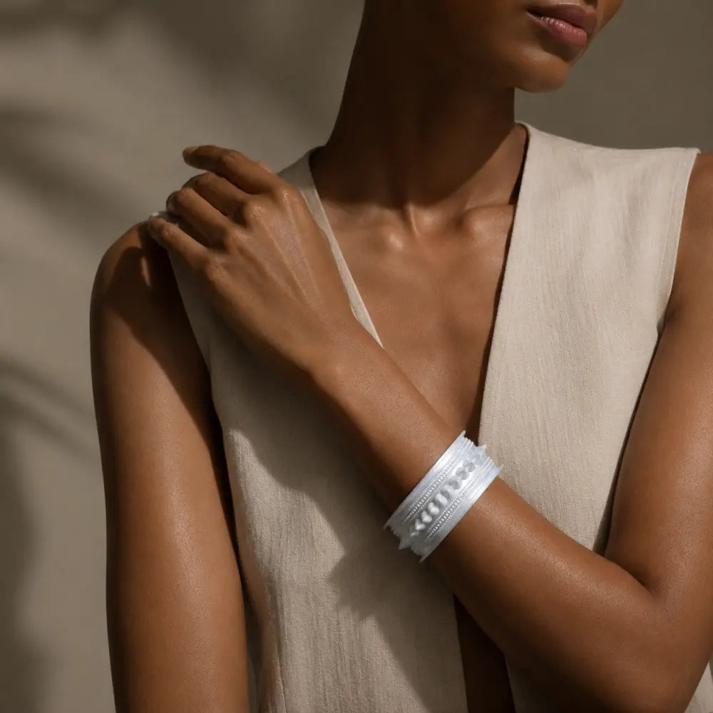 Miao silver patterned bracelet: Wide bracelet worn on a hand resting on a shoulder