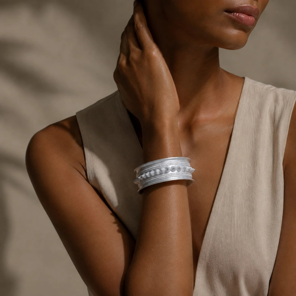 Miao silver patterned bracelet: Wide bracelet worn on a raised wrist beside the neck