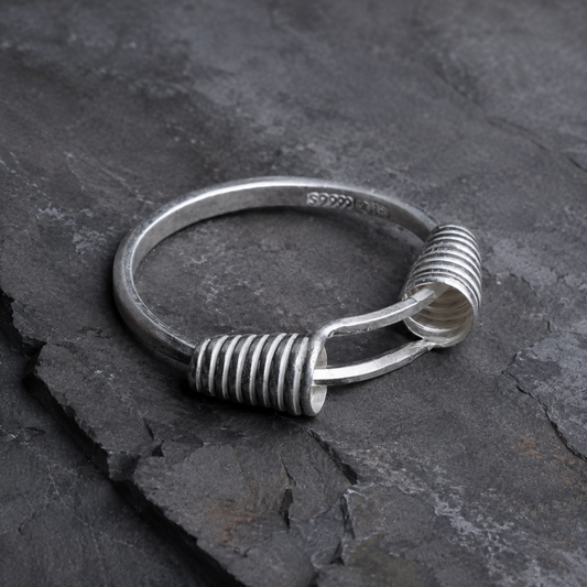 Miao silver spiral bracelet: Angled view of coiled ends on slate