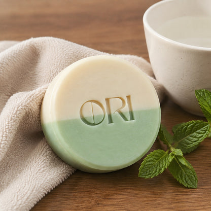 Peppermint and goat milk soap bar: On linen beside a white cup