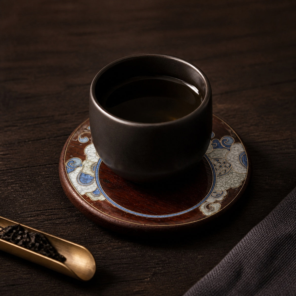 Round red sandalwood cloisonne coaster: Blue floral design beneath a black cup