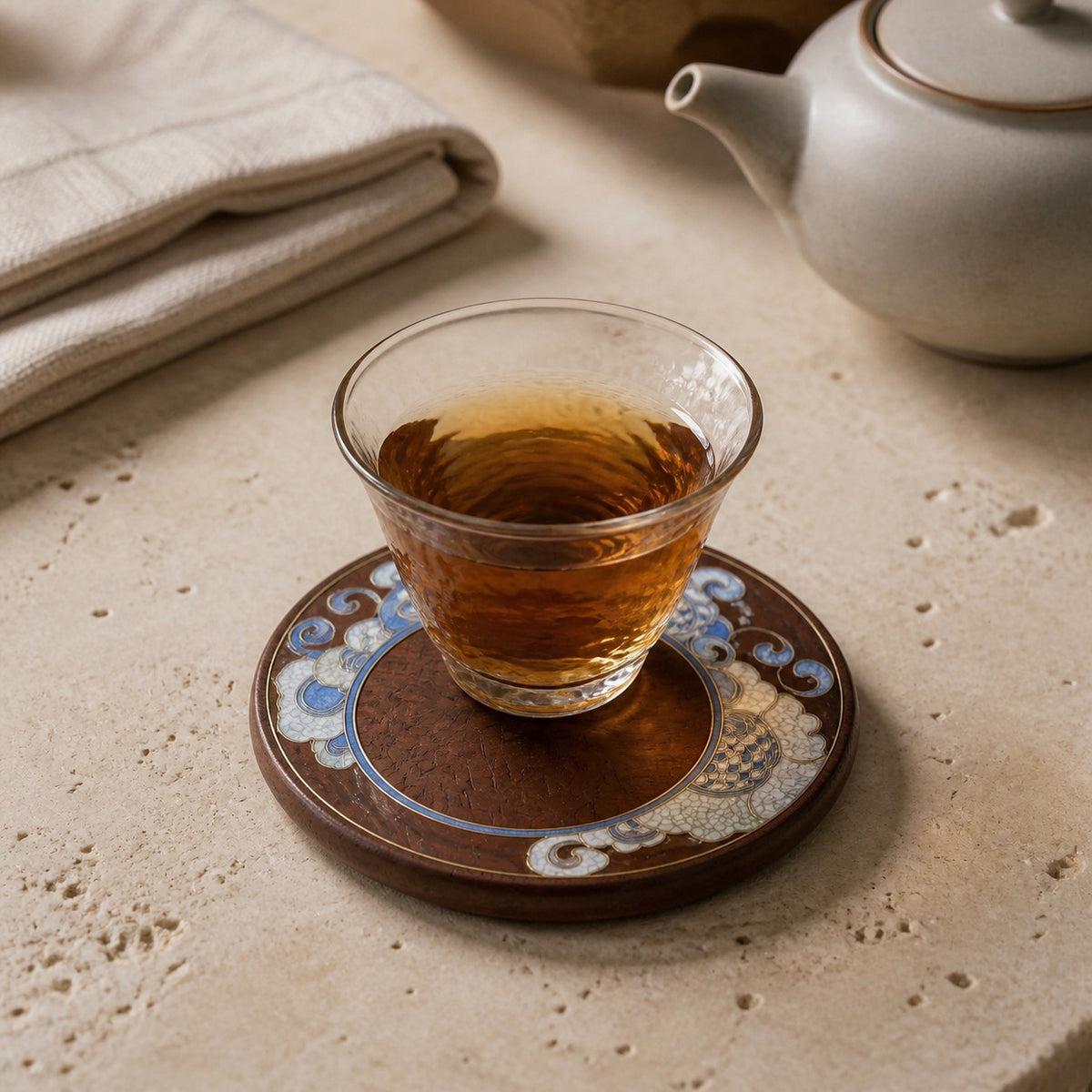 Round red sandalwood cloisonne coaster: Blue floral design beneath a glass teacup
