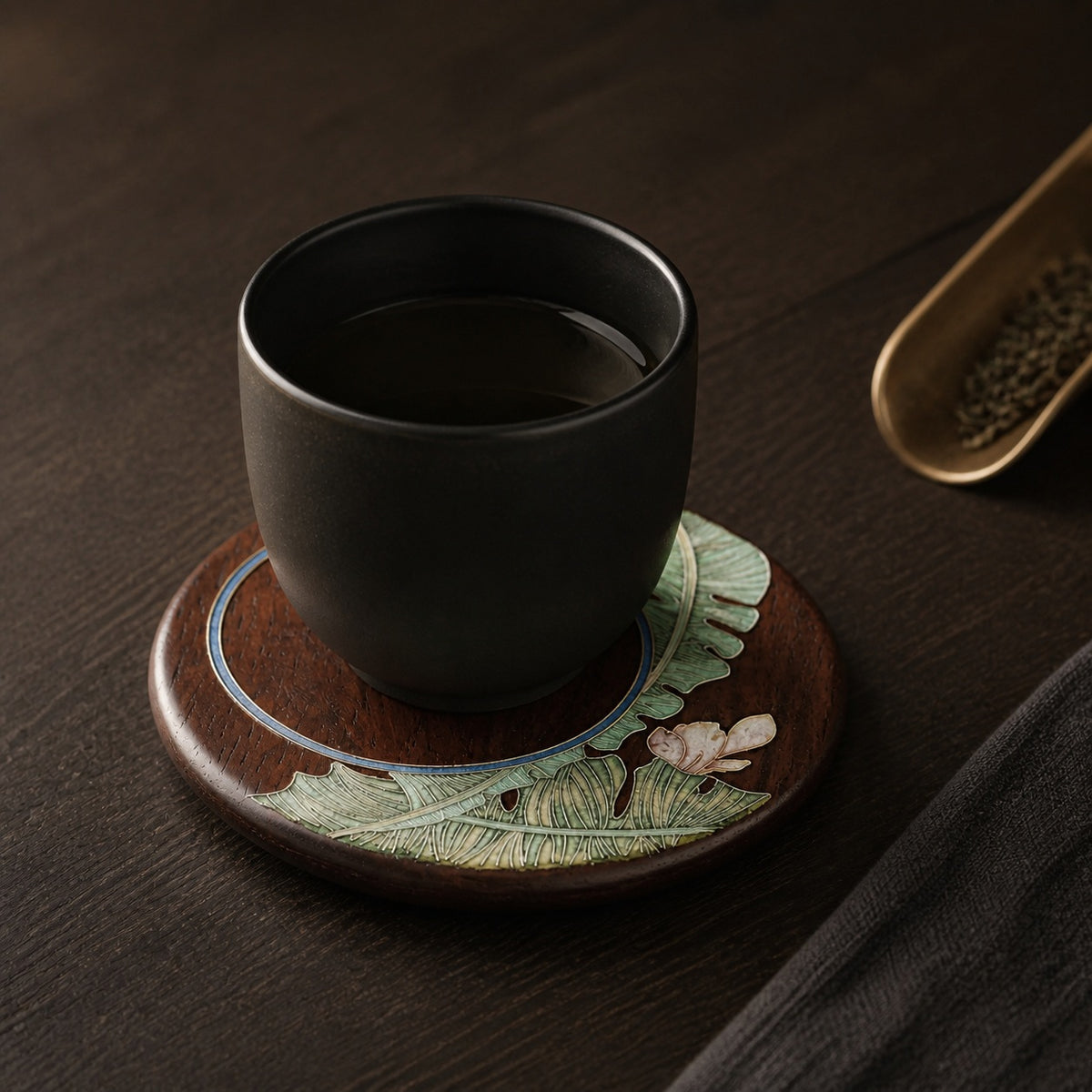 Round red sandalwood cloisonne coaster: Green botanical design beneath a black cup