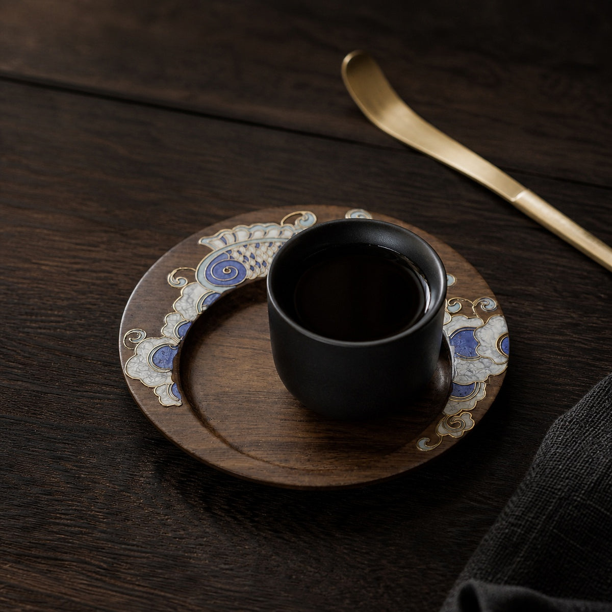 Round walnut cloisonne coaster: Blue floral design beneath a black cup