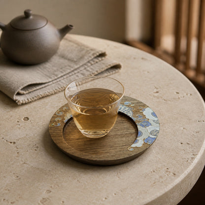 Round walnut cloisonne coaster: Pale blue floral design beneath a glass teacup