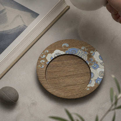 Round walnut cloisonne coaster: Pale blue floral design beside a book