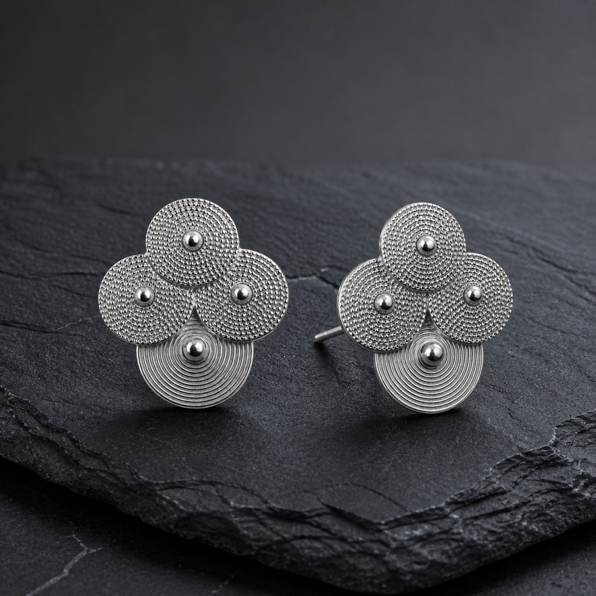 Silver spiral-disc cluster studs: Cluster studs standing on gray slate
