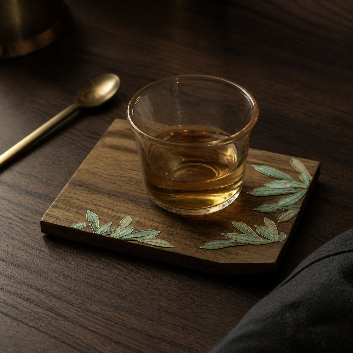 Square walnut cloisonne coaster: Green leaf design beneath a glass teacup