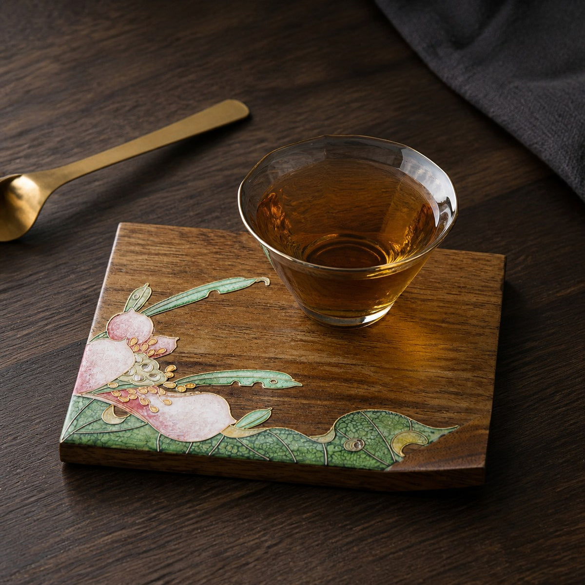 Square walnut cloisonne coaster: Pink floral design beneath a glass teacup