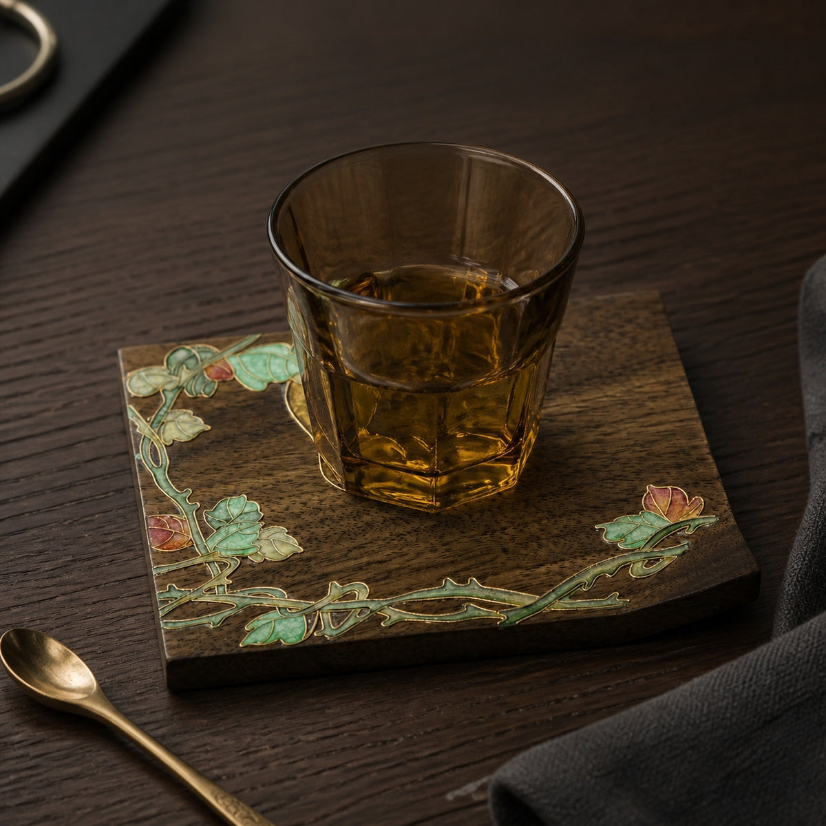 Square walnut cloisonne coaster: Yellow flower and green vine design beneath a glass teacup