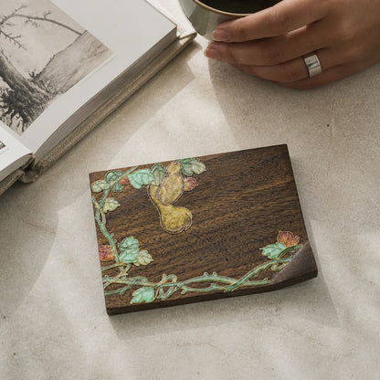 Square walnut cloisonne coaster: Yellow flower and green vine design beside a book