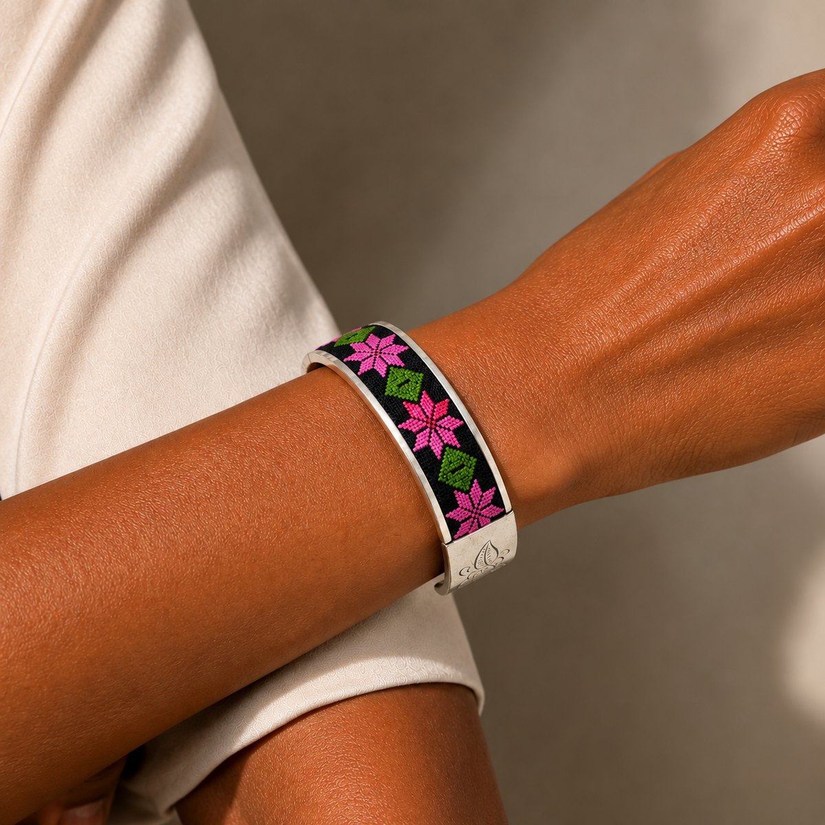 Xixiu embroidered alloy cuff: Pink floral cuff worn on an extended wrist