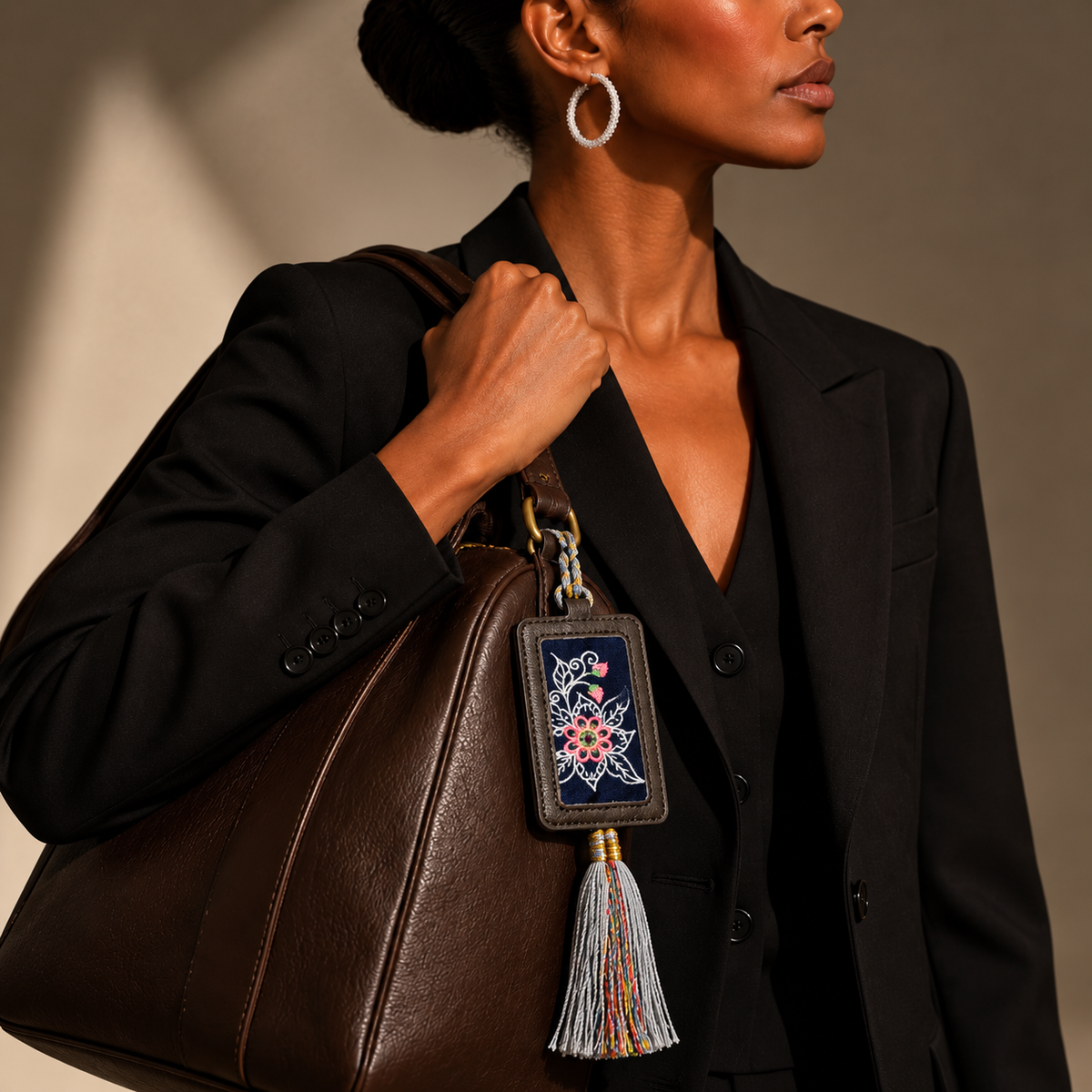 Xixiu embroidered luggage tag: Multicolor floral tag attached to a handbag carried by a model